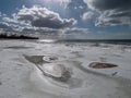 Landscape of Baltic sea and beach with ice and snow formations on the shore in bright sunlight. Frozen ice blocks and sea water in Royalty Free Stock Photo