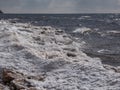 Landscape of Baltic sea and beach with ice and snow formations on the shore in bright sunlight. Frozen ice blocks and sea water in