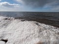 Landscape of Baltic sea and beach with ice and snow formations on the shore in bright sunlight. Frozen ice blocks and sea water in Royalty Free Stock Photo