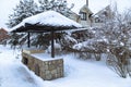 Landscape with barbeque area and winter garden. Snowbanks of white snow,cottages, pine trees background.