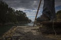 The landscape of a bay framed by the legs of a hiker