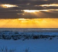 Landscape of the beach area Black sand beach completely covered with snow with golden light of dawn reflected in the sea water Royalty Free Stock Photo