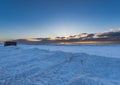 Landscape of the beach area Black sand beach completely covered with snow with golden light of dawn under the clouds and two men Royalty Free Stock Photo