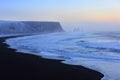 Landscape with beach of black sand and the sea stacks in the background