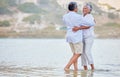 Landscape, beach and dance of a senior couple smiling and dancing in the sea or ocean water and hugging at sunset. Happy Royalty Free Stock Photo