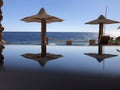 Landscape of beach umbrellas made of palm leaves, view of the emerald ocean and blue sky