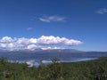 Landscape of a beautiful green field on the background of the lake and mountains Royalty Free Stock Photo