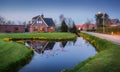 Landscape with beautiful house reflected in water canal at dusk