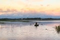 Landscape Beautiful lake in the evening with rower on the oars and small church on the horizon