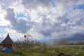 Landscape with beautiful soaring clouds on the background of gardens and bee house