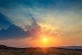 Landscape of beautiful sunset in the desert. View of high sandstone hills and dramatic cloudy sky.