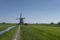 Landscape with beautiful traditional dutch windmills near the water canals with blue sky and clouds reflection in water Royalty Free Stock Photo