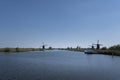 Landscape with beautiful traditional dutch windmills near the water canals with blue sky and clouds reflection in water Royalty Free Stock Photo