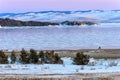 Landscape with beautiful winter frozen lake and snowy mountains at sunset at lake Baikal. Panoramic view