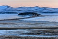 Landscape with beautiful winter frozen lake and snowy mountains at sunset at lake Baikal. Panoramic view