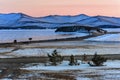 Landscape with beautiful winter frozen lake and snowy mountains at sunset at lake Baikal. Panoramic view