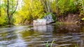 landscape, a big stone in the river stream, colorful trees on the river bank, long time blurs the water in the photo