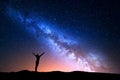 Landscape with blue Milky Way and yellow light. Colorful night sky with stars and silhouette of a standing sporty girl Royalty Free Stock Photo