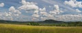 Landscape with blue sky and clouds, field, forest and hills Royalty Free Stock Photo