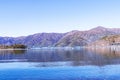 Landscape Bridge over lake and forest with mountain blue sky and bright sunlight in background. Royalty Free Stock Photo