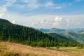 Landscape of bright summer day in Carpathian mountains, panorama of Carpathians, blue sky, trees and green hills, beautiful view