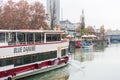 Landscape with buildings and cruise ship sailing at the riverbank of Donaukanal Danube cannal in a rainy day, , in Vienna,