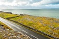 Landscape in Burren area by Atlantic ocean, West of Ireland. Small narrow asphalt road by the ocean, part of Wild Atlantic Way Royalty Free Stock Photo