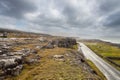 Landscape in Burren area by Atlantic ocean, West of Ireland. Small narrow asphalt road by the ocean, part of Wild Atlantic Way Royalty Free Stock Photo