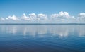 Landscape of calm lake, blue sky with clouds reflected in the water Royalty Free Stock Photo