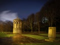 Landscape of a cemetery at night with a distant tree line in the background