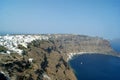 Greek island of Thirasia near to Santorini. View of cliffs and a bay with the old town of Manolas on the sky line. Royalty Free Stock Photo