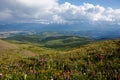 Landscape. Clouds over mountains and hills, flower fields Royalty Free Stock Photo