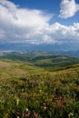 Landscape. Clouds over mountains and hills, flower fields Royalty Free Stock Photo