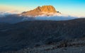 Landscape of the cloudy peak of Mount Kilimanjaro under sunlight with shadow in front Royalty Free Stock Photo