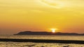 Landscape of colorful sunset shining over bright orange waters of the ocean. Silhouette paradise island of beautiful tropical