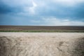 Landscape consisting of a plowed field road and sky. Belarusian rural landscape