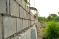 Landscape of construction site with concrete bricklayer wall and blurred hand of worker installing the bricks on the wall in