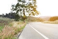 A landscape of curve long asphalt road to the mountain in a nature for blur background photo, a big tree on the left hill, dried