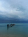 Landscape with dark sky with storm clouds over the ocean. Destroyed pier at Bophut beach on Koh Samui in Thailand. Royalty Free Stock Photo