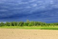 Dark thundercloud clouds under the forest and land