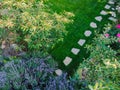Landscape design with flower beds and path, natural landscaping panorama in home garden. Aerial view