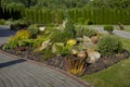 Landscape design in home garden, natural landscaping with flower bed and decorative stones in backyard. Beautiful landscaped garde Royalty Free Stock Photo