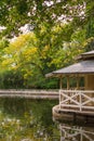 Landscape with detail of small house on the edge of a pond with autumnal vegetation, in vertical Royalty Free Stock Photo