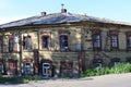 Landscape with a dilapidated building. A crumbling two-story house.