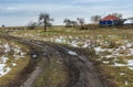 Landscape with an dirty earth road leading to remote Ukrainian village in Sumskaya oblast Royalty Free Stock Photo