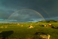 Landscape with a double rainbow over a wide field and grazing horse Royalty Free Stock Photo