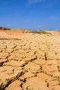 Landscape with dry cracked soil and blue sky Royalty Free Stock Photo