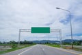 The landscape of empty road through fields with a blank highway sign. Green billboard for text