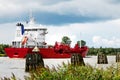 Nord-Ostsee-Kanal with red cargo ship near Rendsburg, Germany Royalty Free Stock Photo