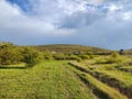 Landscape featuring a road cutting through a grassy field Royalty Free Stock Photo